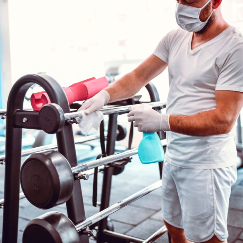 Gym cleaning professionals sanitizing fitness equipment