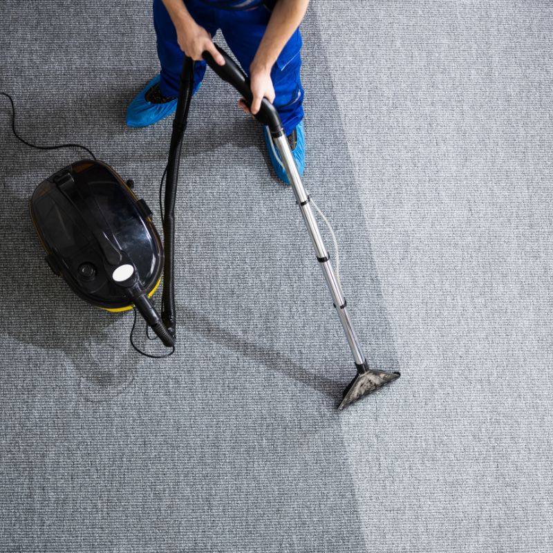 Commercial carpet cleaning technician cleaning office carpets